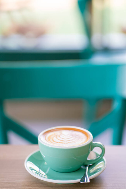 Horké latte art káva v zeleném šálku na dřevěném stole aroma nápoj - Fotografie, Obrázek