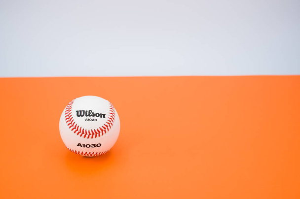 INVERIGO, ITALY - Dec 08, 2021: isolated baseball ball on orange paper background with text space - Zdjęcie, obraz