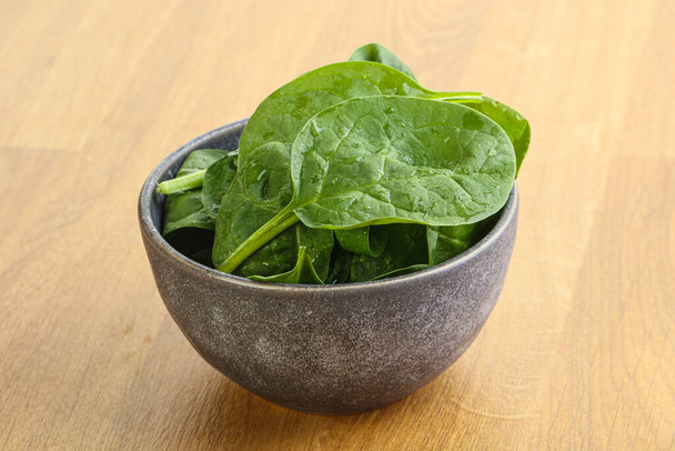 Fresh green spinach leaves in the bowl over wooden background - Foto, immagini