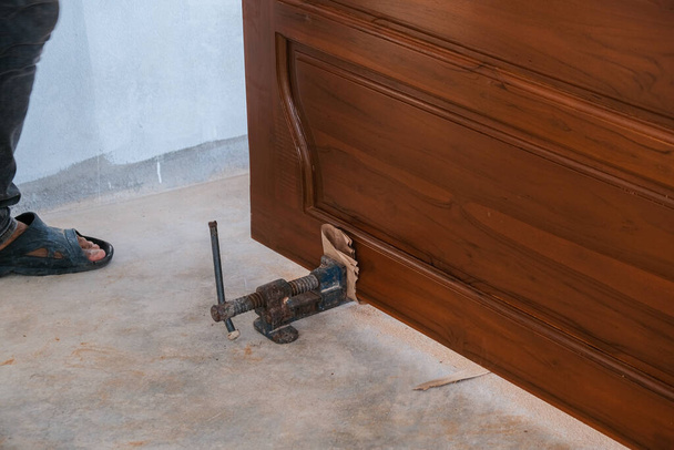 Робочий інструмент для дерев'яних дверей з тикового дерева, встановлений у новому будинку тесляр, що працює
 - Фото, зображення