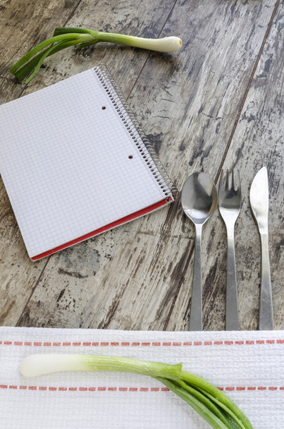 einfacher Hintergrund für Menü mit Besteck, Zwiebeln und Notizblock - Foto, Bild