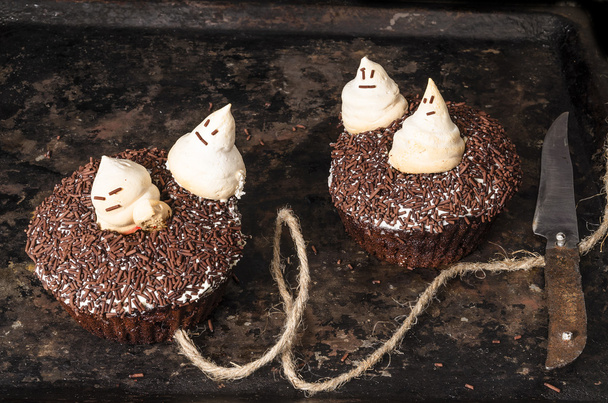 Kaksi suklaa kurpitsa cupcakes, koristeltu marenki aaveita
 - Valokuva, kuva