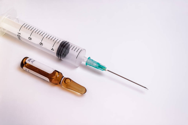 The syringe needle and a medication vial isolated on a white background - Foto, Bild