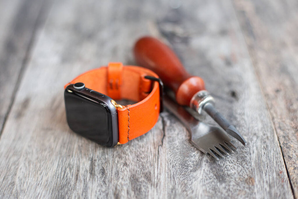 Orange leather smart watch strap hand made on wood craftmanship working - Foto, Imagem