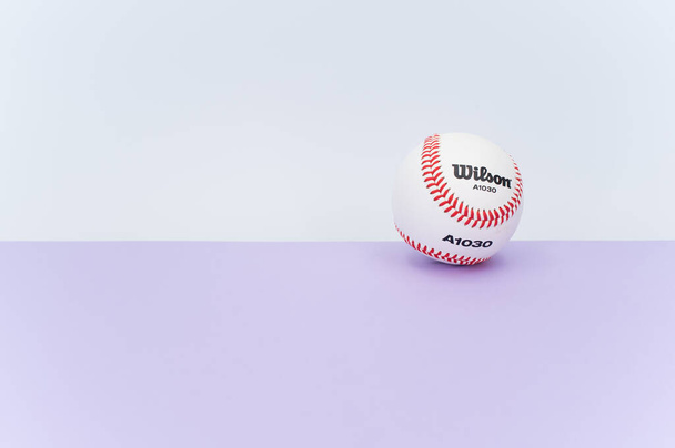 INVERIGO, ITALY - Dec 08, 2021: isolated baseball ball on a lilac background with text space - Photo, Image