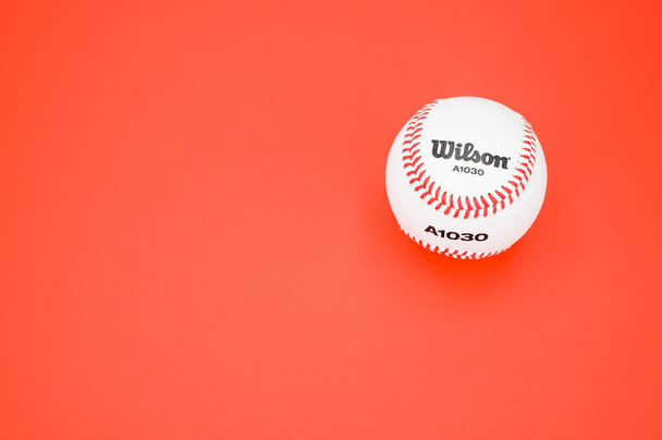 INVERIGO, ITALY - Dec 08, 2021: isolated baseball ball on a red background with text space - Fotografie, Obrázek