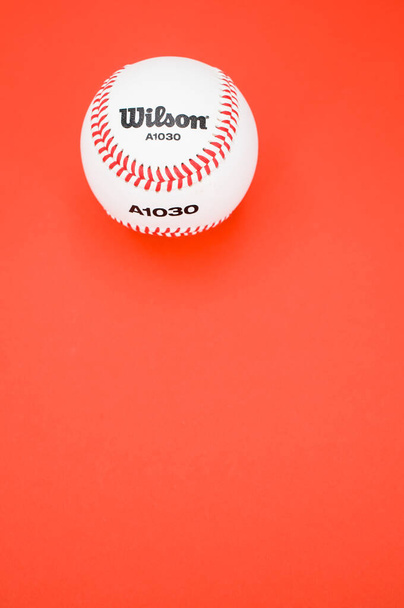 INVERIGO, ITALY - Dec 08, 2021: isolated baseball ball on a red background with text space - Zdjęcie, obraz