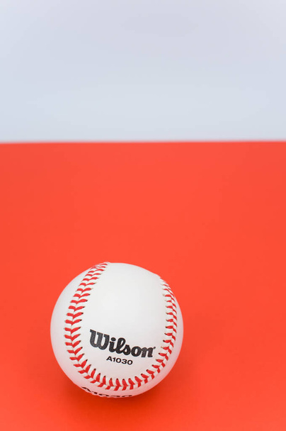 INVERIGO, ITALY - Dec 08, 2021: isolated baseball ball on a red background with text space - Photo, Image
