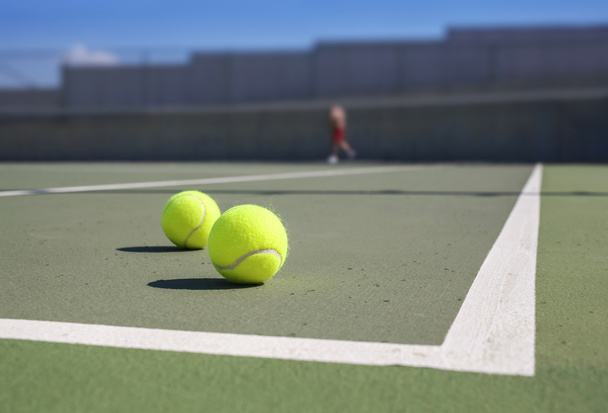 ベースラインの近くに 2 つのテニス ボール - 写真・画像