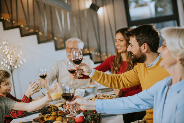 幸せな家族は家で赤ワインと夕食を持っています - 写真・画像