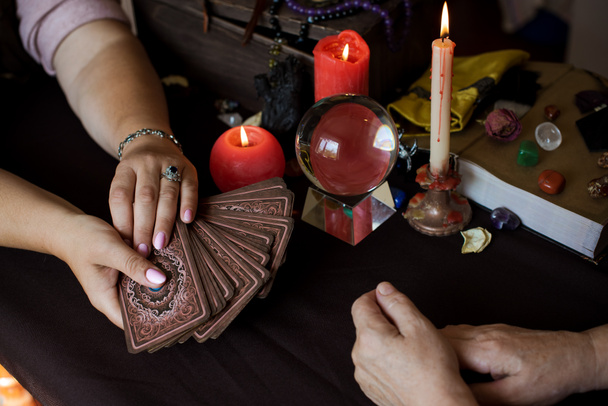Altaar van wicca, kaars, magische boeken, tarotkaarten en andere heksenspullen. Mystieke achtergrond met rituele esoterische objecten, occult, waarzeggerij en Halloween concept - Foto, afbeelding
