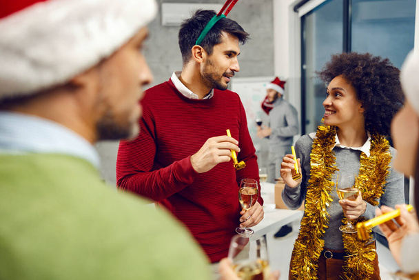 Nouvel An et célébration de Noël. Groupe d'amis multiculturels avec des verres de champagne dans leurs mains debout à l'intérieur et célébrer le Nouvel An. - Photo, image