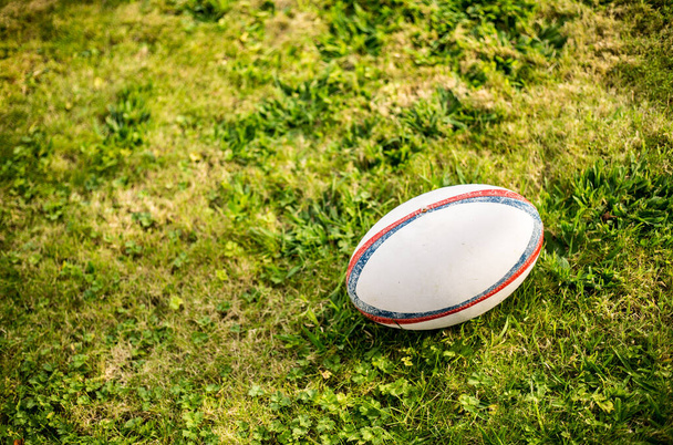 Balón de rugby, Gilbert, en el campo de deportes con hierba verde para el juego de rugby. Centrarse en la pelota, base deportiva en el fondo. - Foto, Imagen