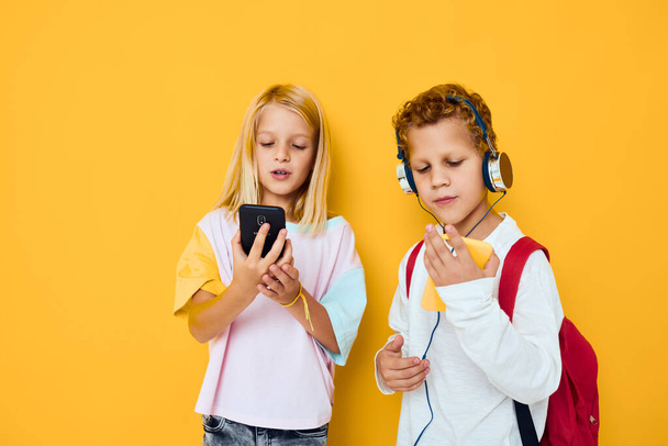 Due bambini ragazzo e ragazza in cerca di uno smartphone e giocare Studio concetto di istruzione - Foto, immagini