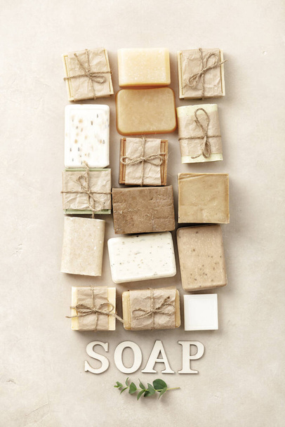 Flat lay composition with handmade soap bars and wood letters on beige background - Foto, Imagen