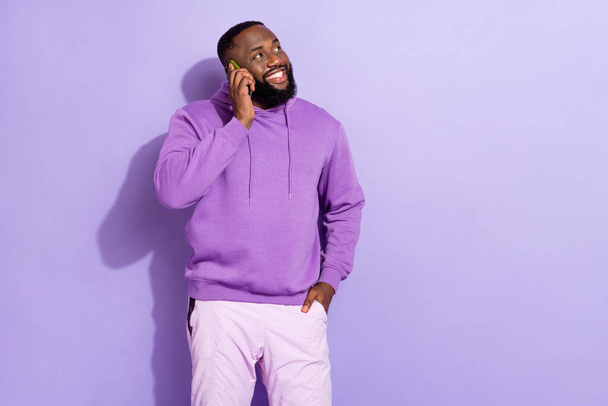 Portrait d'attrayant gai gars parlant sur l'espace de copie de téléphone itinérance isolé sur fond violet couleur pourpre - Photo, image