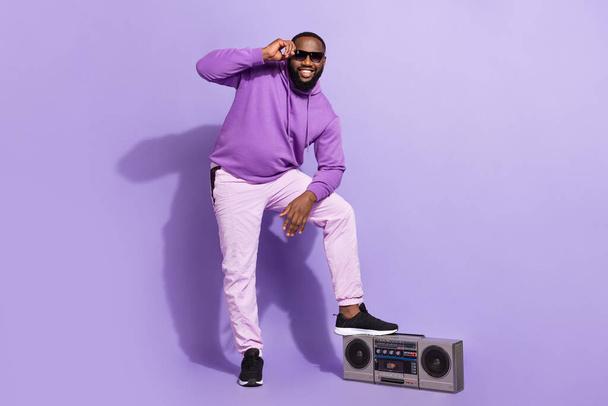 Full length body size view of attractive cheerful funny guy dj with tape player touching specs isolated on violet purple color background - Photo, image