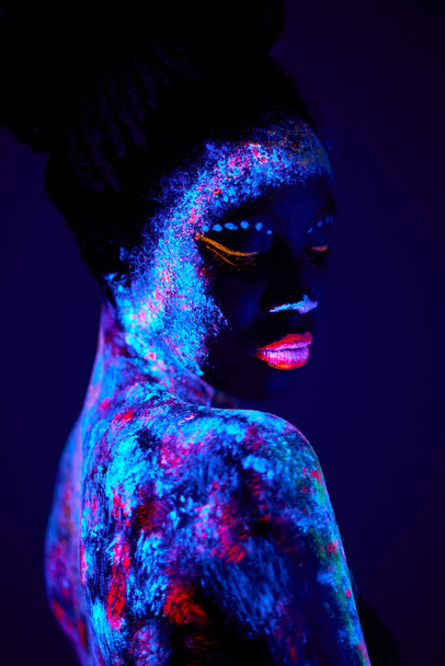 attractive sensual woman of black appearance in fluorescent paint makeup - Фото, изображение