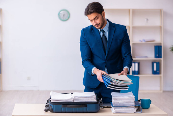 Young male employee preparing for business trip at workplace - Photo, Image