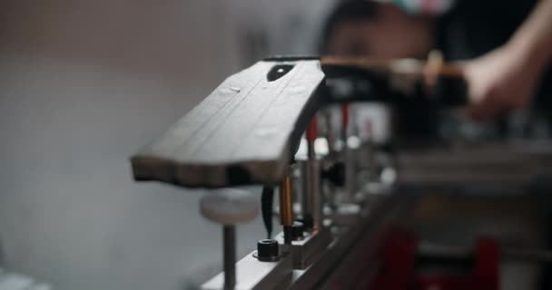 Gitarrenbauer montiert die E-Gitarre auf der Jig in der Musikinstrumentenwerkstatt, 4k 60p 10 bit - Filmmaterial, Video