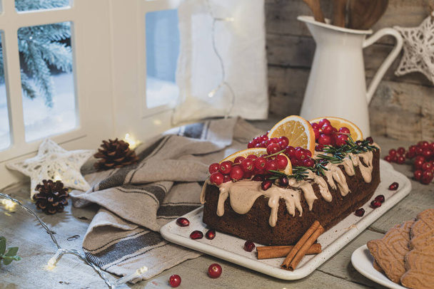 Tradycyjne ciasto cynamonowe świąteczne ozdobione owocami i kremem spekulacyjnym ciasteczka na blat kuchenny. - Zdjęcie, obraz