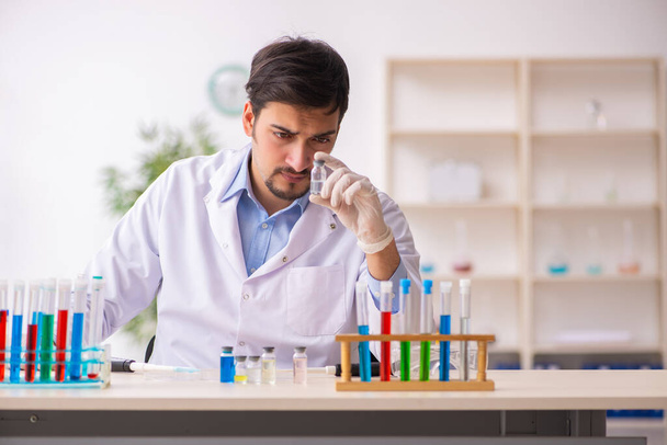 Молодий хімік-чоловік працює в лабораторії
 - Фото, зображення