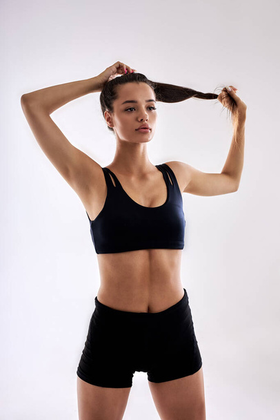 attractive slim fitness woman making ponytail preparing for sport workout - Foto, Imagem