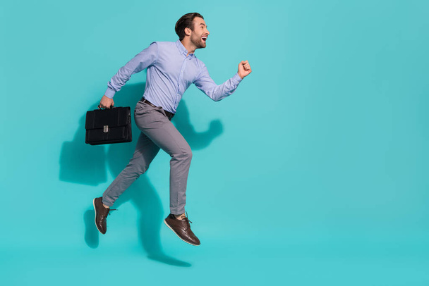 Profile photo of busy corporate office worker hold brief case run fast wear purple shirt isolated teal color background - 写真・画像