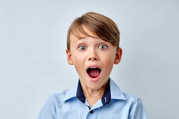little boy amazed by news with opened mouth isolated gray color background - Foto, immagini