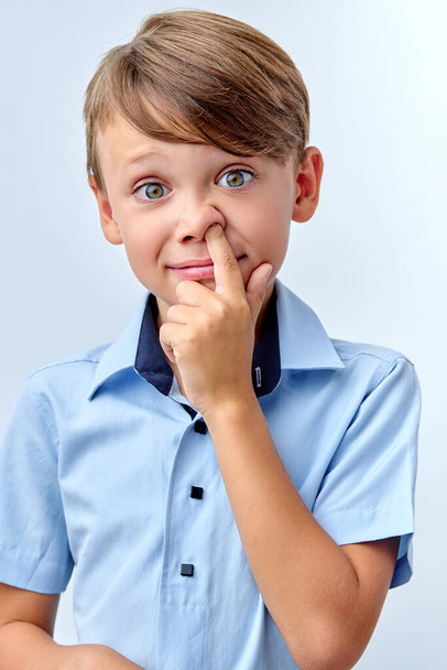 Boy pokes nose with finger. Caucasian kid pulls out the boogers. Bad manners - Fotoğraf, Görsel