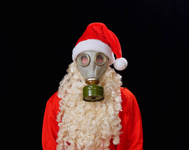 portrait of santa claus santa in a protective mask gas mask on a black background 2021 - Photo, Image