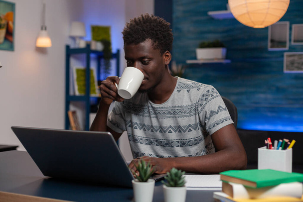 Portrait de jeune entrepreneur afro-américain assis au bureau - Photo, image