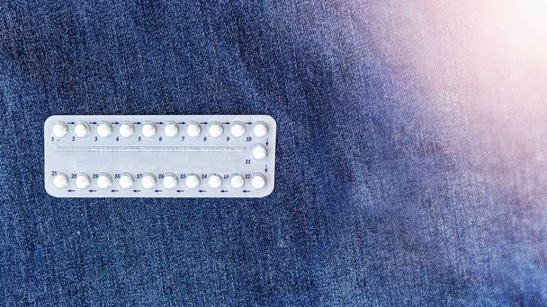 contraceptive pills lie on a jeans background. Selective focusThe concept of sexual education for adolescents. Contraceptive selection by partners. Planning children in the family. Taking care of the health of the sexual partner. - Photo, Image
