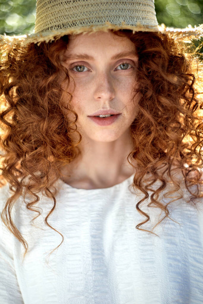 Sensual caucasian redhead female with curly wavy hair posing, looking at camera - Fotó, kép