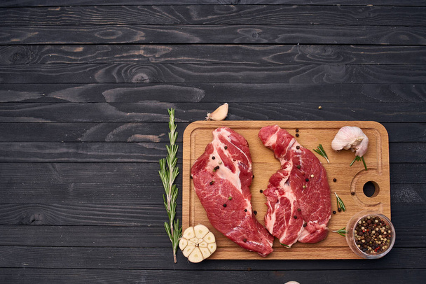 meat steak wooden board and spices ingredients top view - 写真・画像