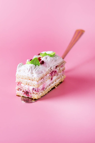Piece of of Tasty Homemade Biscuit Cake Tasty Dessert with Cream Pink Background Vertical - Photo, Image