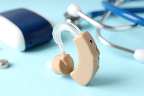 Begrip gezondheidszorg met gehoorapparaat op blauwe achtergrond - Foto, afbeelding