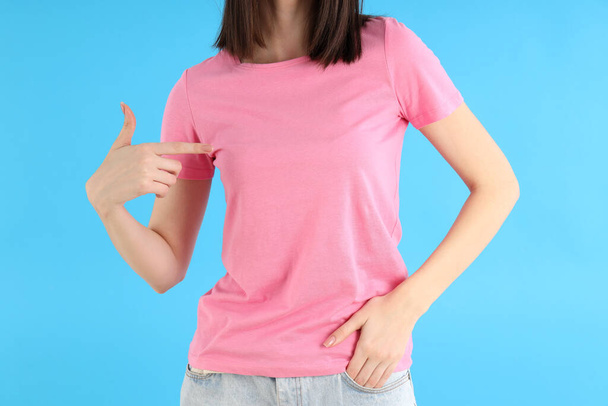 Attractive girl in pink t-shirt on blue background - Zdjęcie, obraz