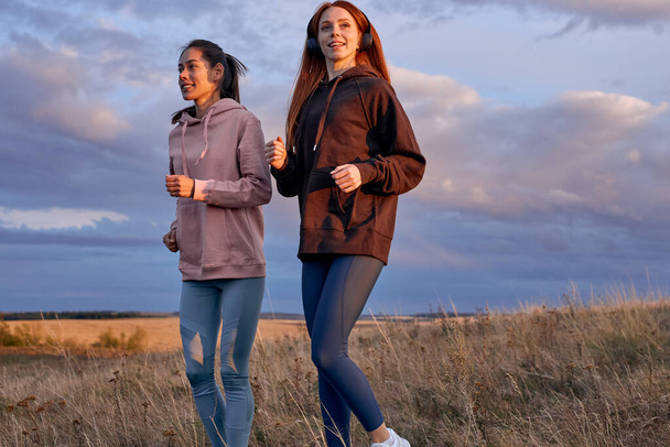 women in sportswear, practicing running jogging on mountain field at sunrise - Foto, Imagen