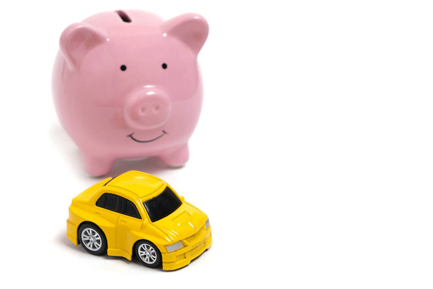 Piggy bank and yellow car on white background - Foto, imagen