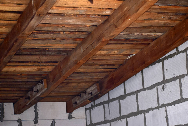 Op de foto een close-up van een deel van het dak, twee genaaide balken en een vleermuis. - Foto, afbeelding