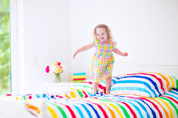 Petite fille sautant sur un lit
 - Photo, image
