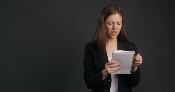 Спритна і сердита жінка в чорному костюмі схрещує куски в блокноті, крихкий аркуш паперу і викидає його, 4k Prores HQ - Кадри, відео
