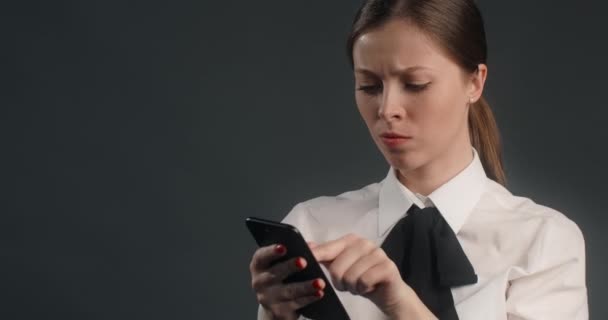 Hämmentynyt ja tyytymätön eurooppalainen nainen pyyhkäisee älypuhelimen näytön kiireessä, vihainen toimistotyöntekijä käyttää puhelinta, 4k Prores HQ 10 bit - Materiaali, video
