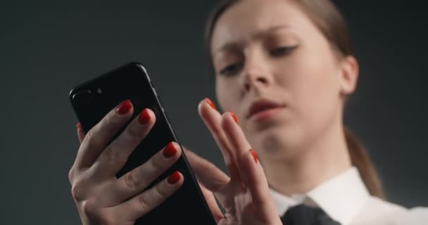 Hämmentynyt ja tyytymätön eurooppalainen nainen pyyhkäisee älypuhelimen näytön kiireessä, vihainen toimistotyöntekijä käyttää puhelinta, 4k Prores HQ 10 bit - Materiaali, video