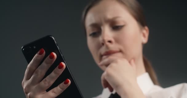 Tyytymätön eurooppalainen nainen pyyhkäisee älypuhelimen näytön kiireessä, käyttäjä kieltäytyy viesteistä ja sovelluksista matkapuhelimessa, vihainen toimistotyöntekijä käyttää puhelinta, 4k Prores HQ 10 bit - Materiaali, video