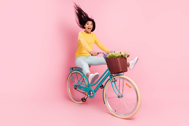 Portrait of nice crazy amazed funny cheerful girl riding bike fooling having fun isolated over pastel pink color background - Foto, Imagem