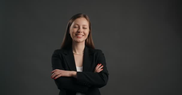 Femme d'affaires européenne en costume noir montres à la caméra et sourires, 4k Prores HQ - Séquence, vidéo