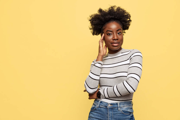 Half-length portrait of young African woman in warm casual style clothes isolated on yellow background. Concept of emotions - Valokuva, kuva