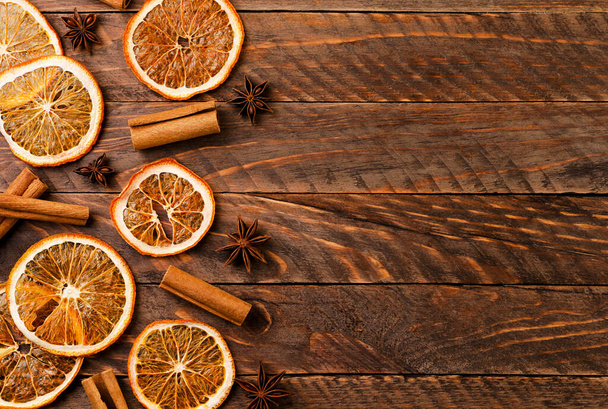 Сушеный апельсин, корица и анисовый анис крупным планом на деревянном фоне, вид сверху. Рождественский фон - Фото, изображение
